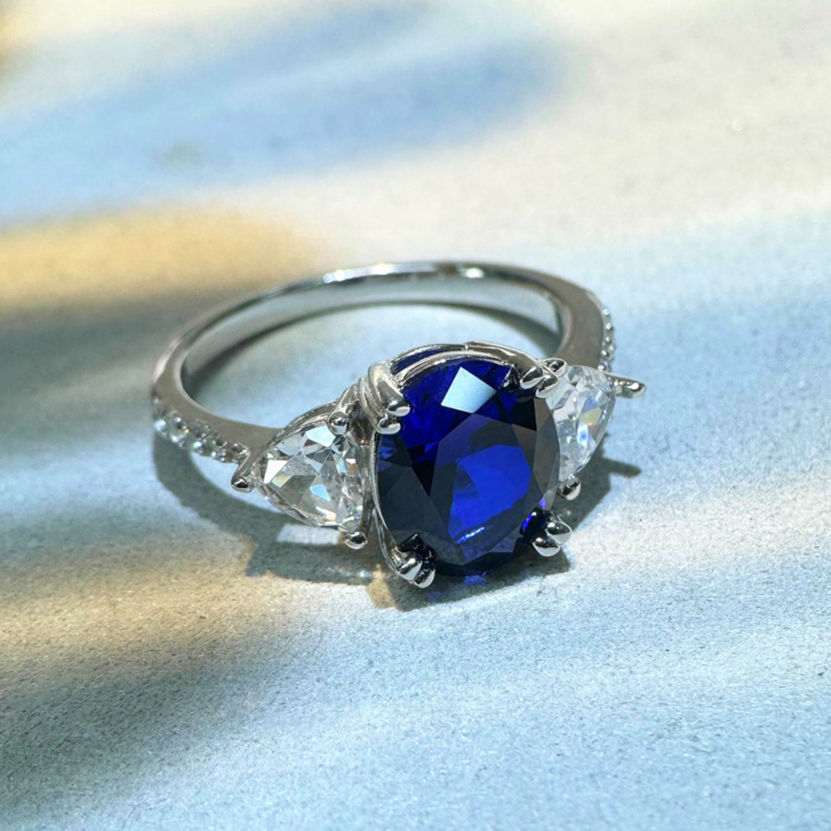 Oval Blue Sapphire Three-Stone Ring with Accent Stones — main image