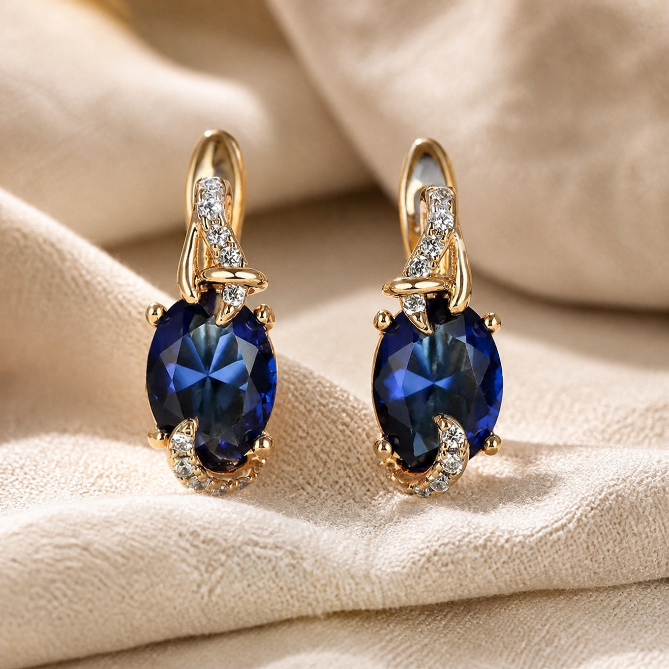 Oval Blue Sapphire Drop Earrings with Swirled Gold Setting