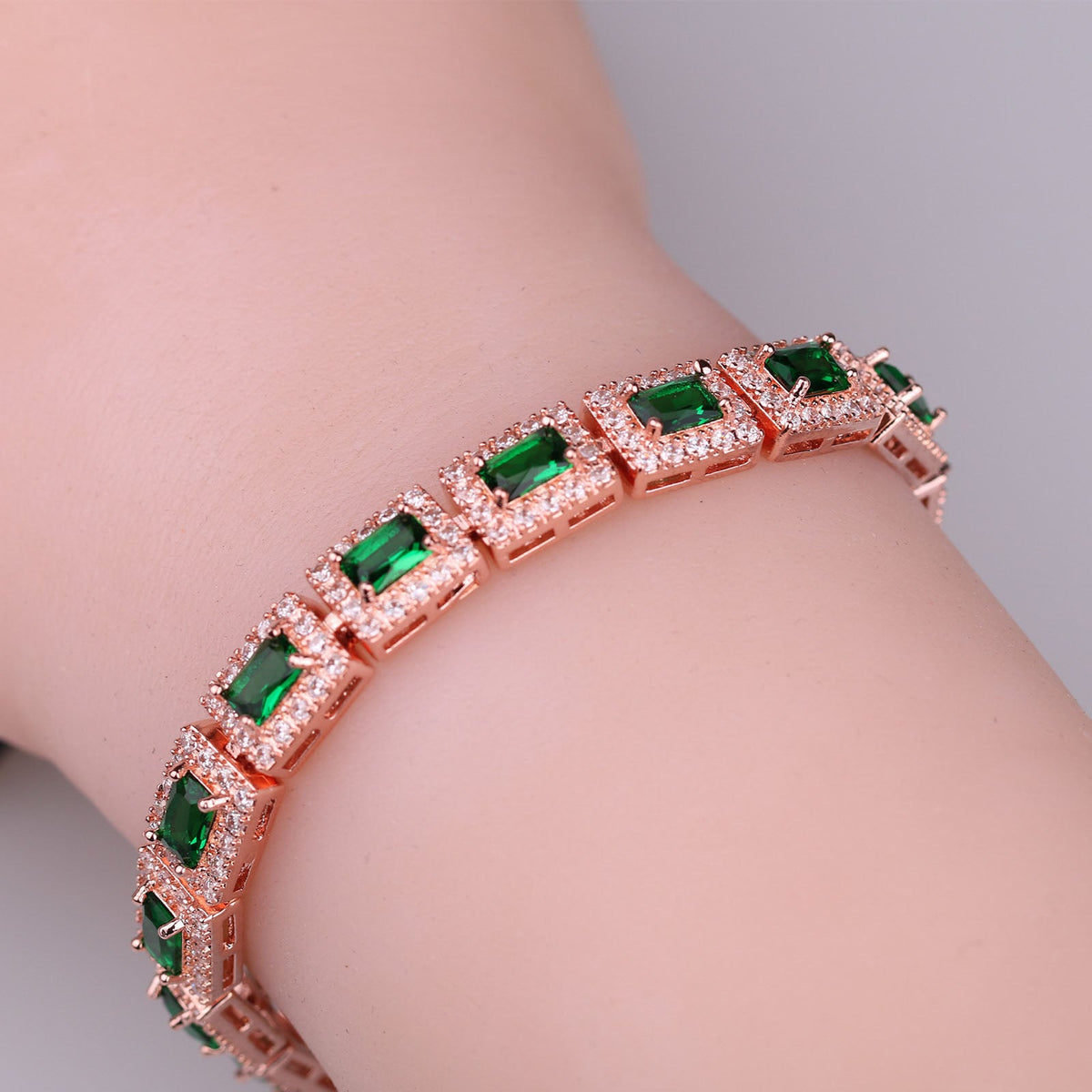 Emerald-Cut Green Stone Tennis Bracelet with Rose Gold Tone and Halo Accents — view 3
